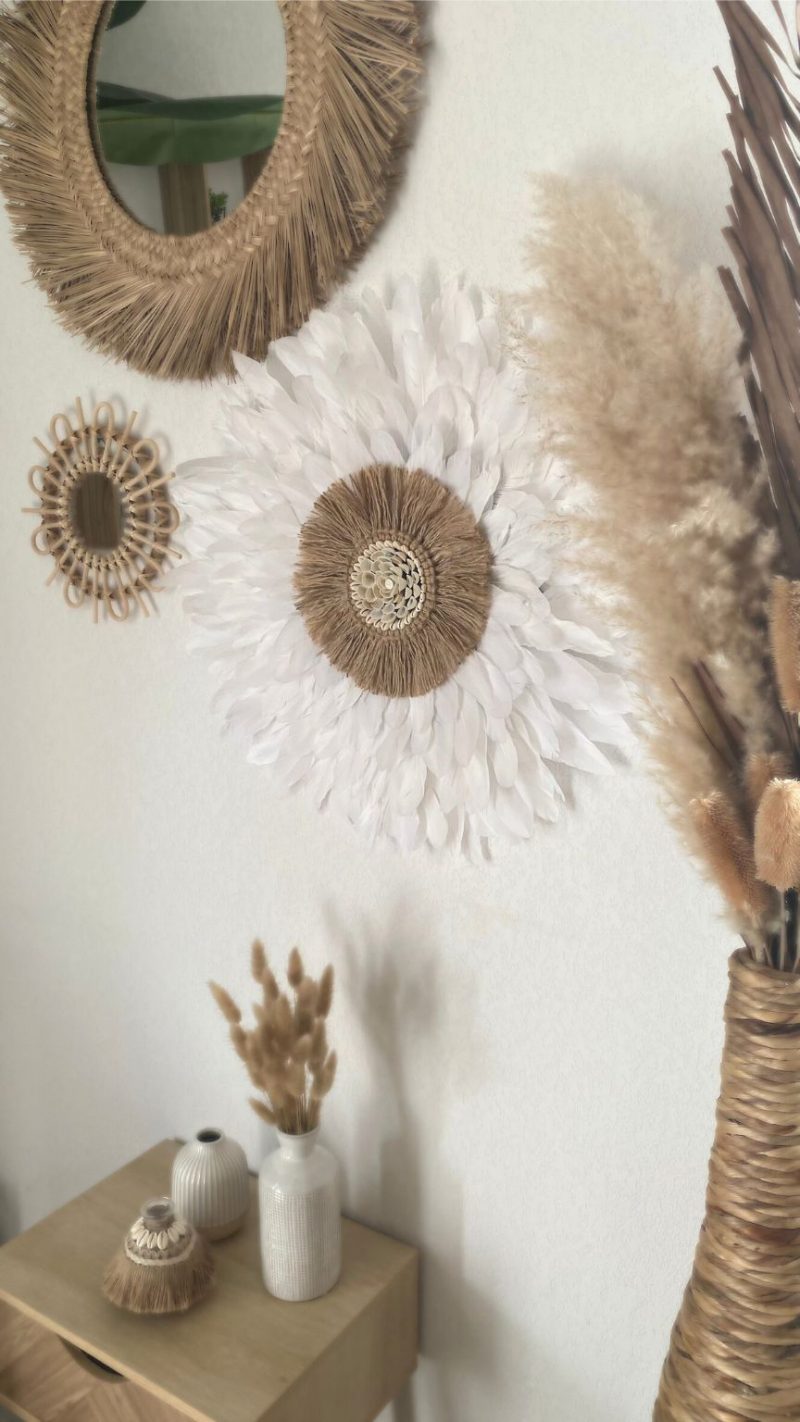 Mur décoré avec un juju hat bohème en plumes blanches, des miroirs en fibres naturelles