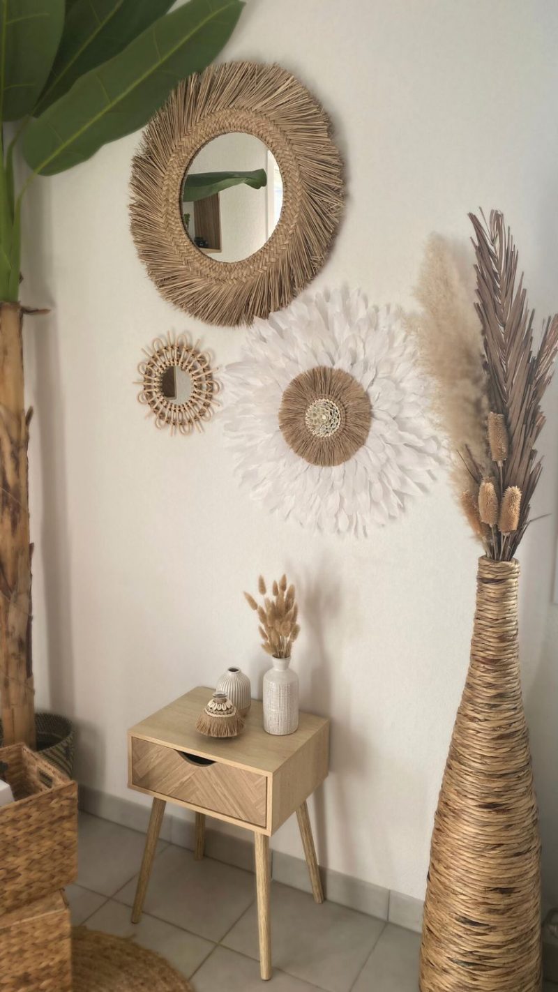 Mur décoré avec un juju hat bohème en plumes blanches, des miroirs en fibres naturelles