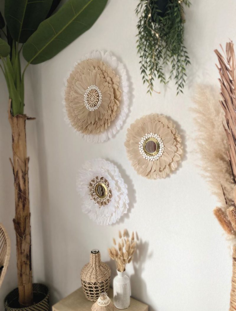 Trois miroirs muraux juju hats artisanaux naturels ornés de plumes dans des tons beige et blanc avec miroir central en laiton et coquillages,