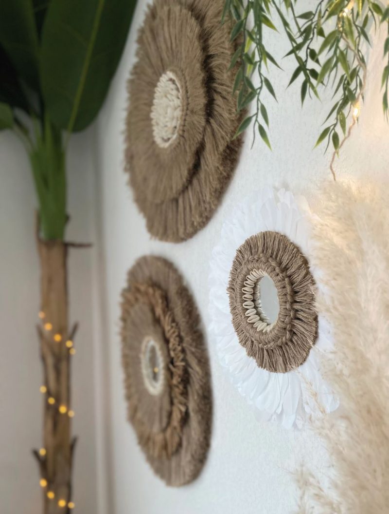 Miroirs faits main en jute et plumes, accrochés dans une décoration naturelle