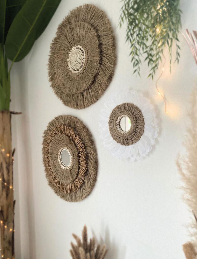 Trois miroirs muraux faits main en jute et plumes, accrochés dans une décoration naturelle