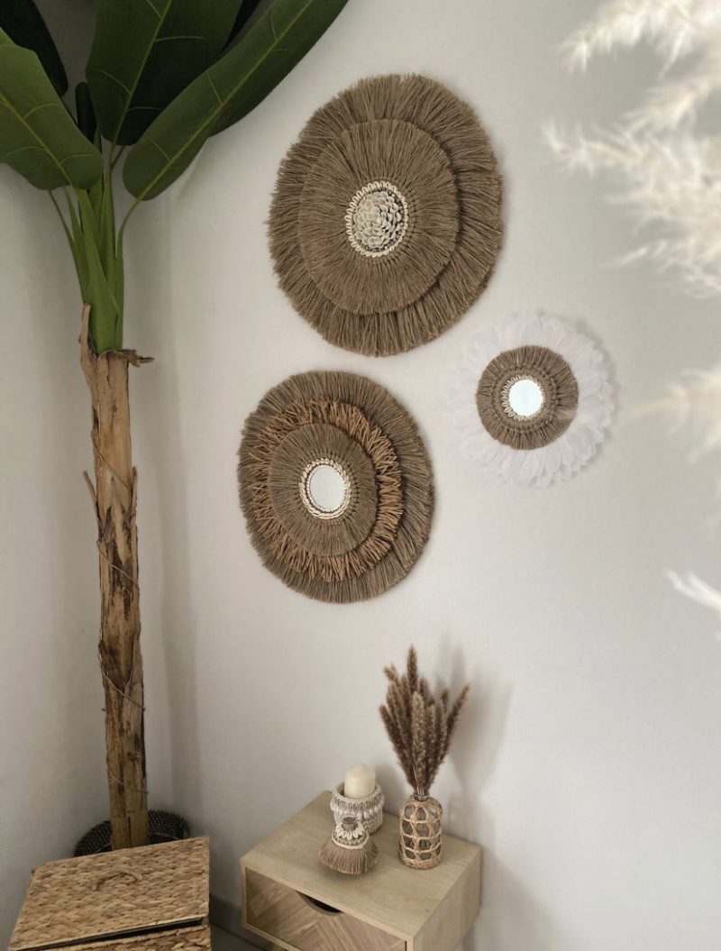 Trois miroirs muraux faits main en jute et plumes, accrochés dans une décoration naturelle