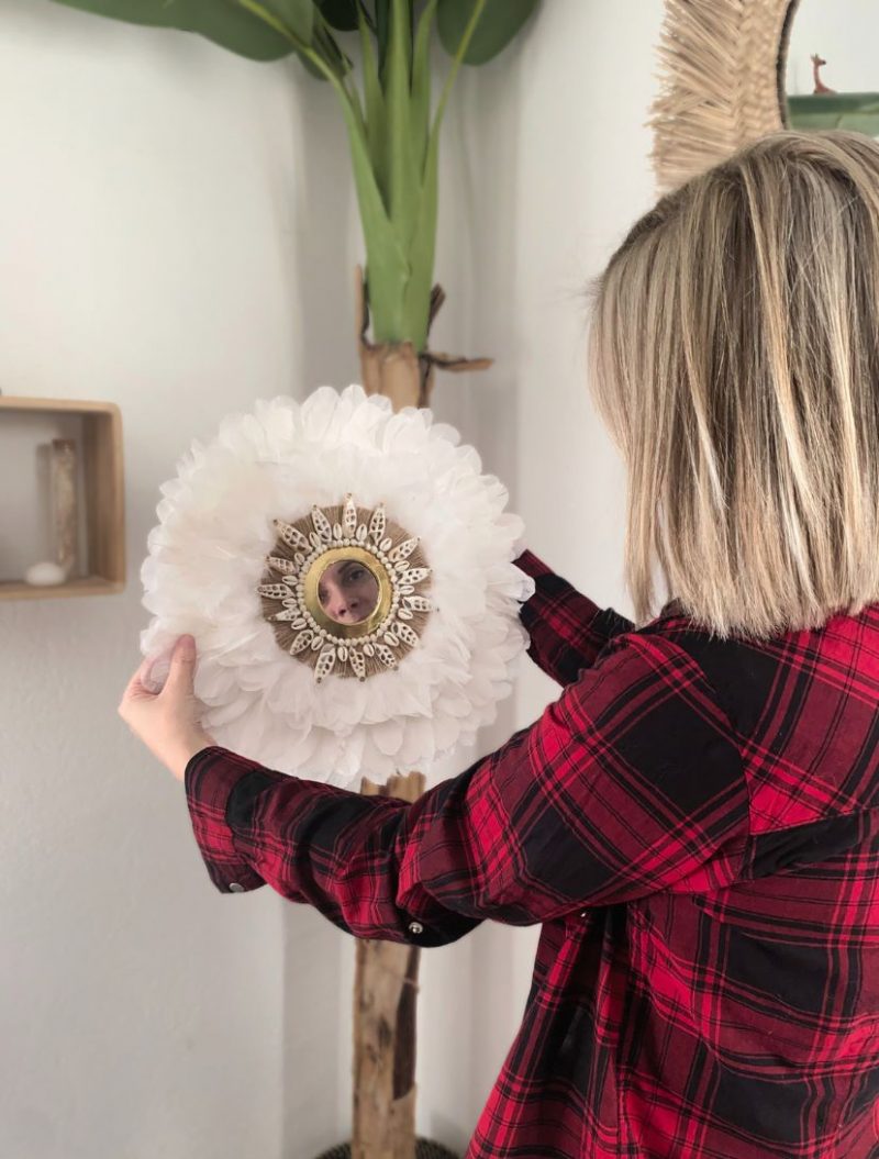 Créatrice présentant un miroir juju hat fait main en plumes blanches, coquillages et corde, déco bohème artisanale inspirée du Maroc